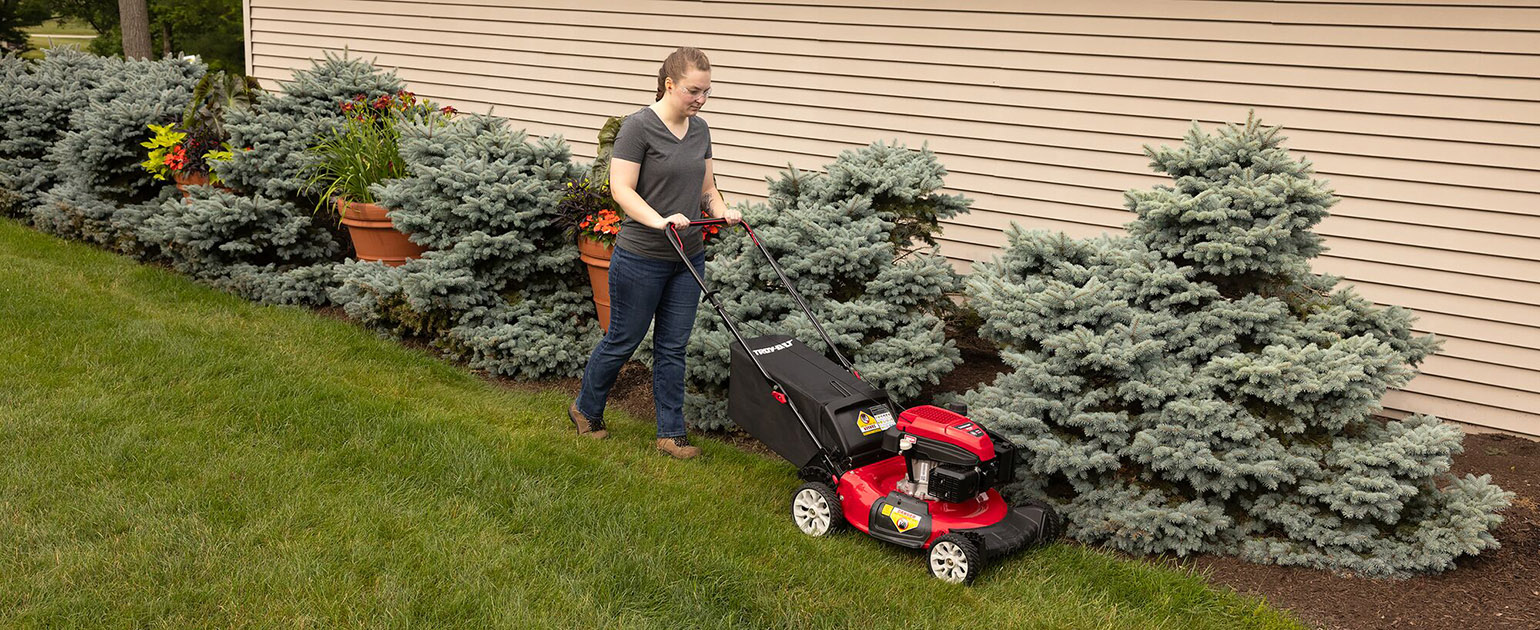 woman mowing her lawn with push mower